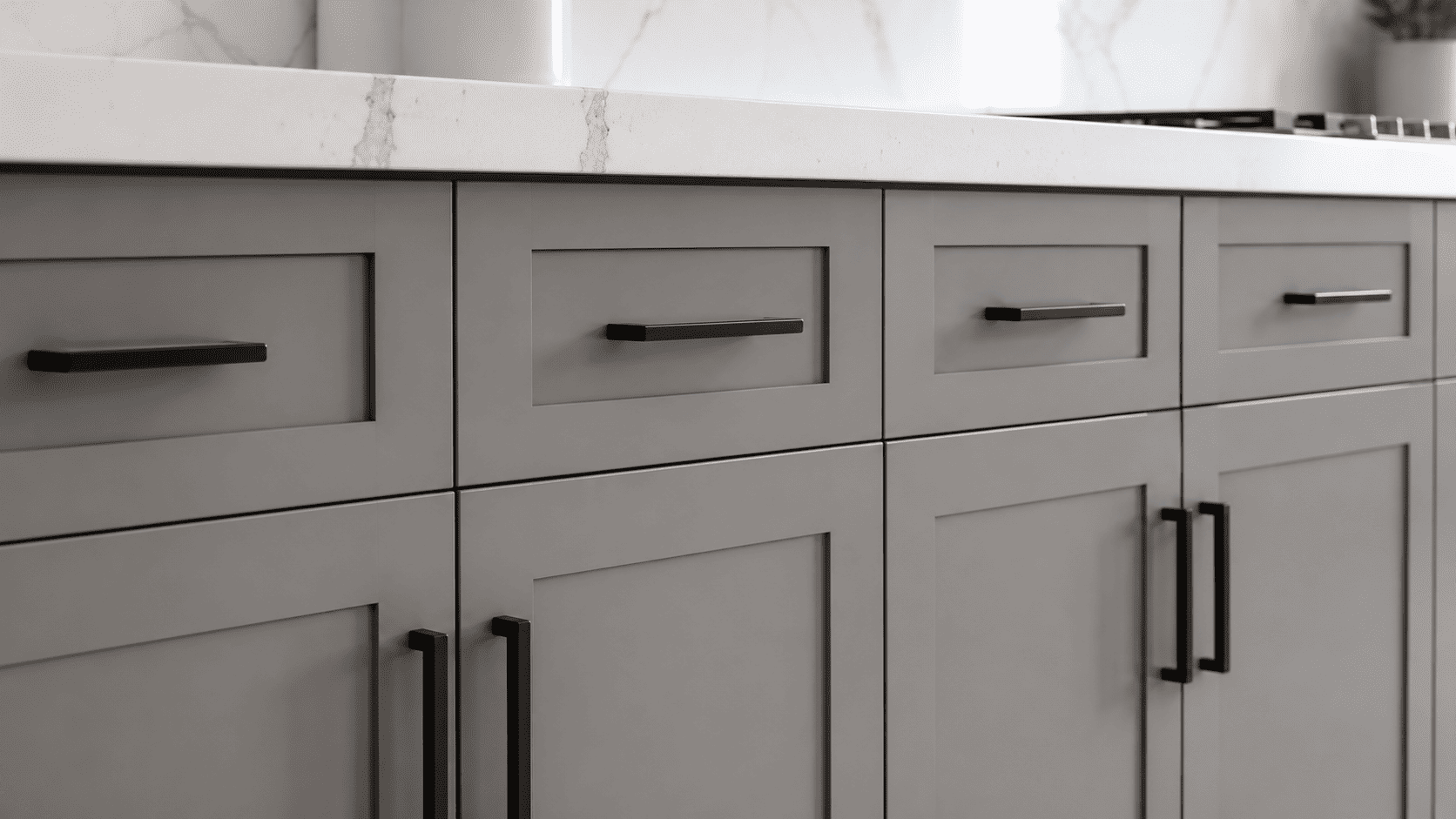 Close-up of gray shaker cabinet doors with sleek matte black pulls
