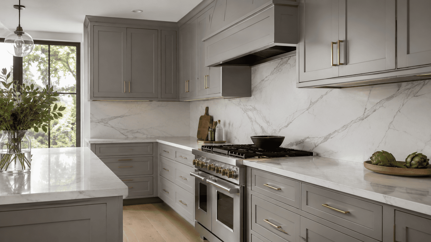 Gray shaker cabinets paired with white quartz countertops and full-height slab backsplash