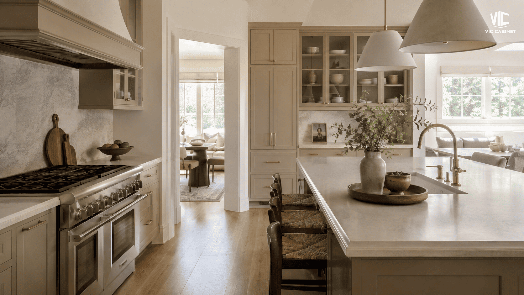 Warm beige painted kitchen cabinets with light oak flooring and brushed brass hardware